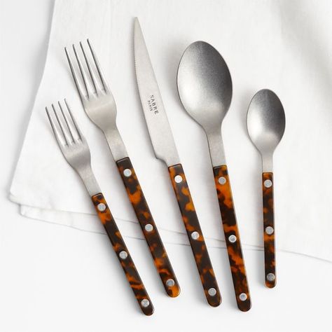 Inspired by well-loved bistro flatware, this 20-piece set brings French cafe style to your table. Stunning tortoiseshell handles sandwich streamlined stainless steel heads that have been given a vintage finish, secured with visible rivets. The result is a modern take on retro flatware—simple and liveable with a touch of edge.     18/10 stainless steel with vintage finish  Acrylic handles  Set includes four 5-piece place settings: dinner fork, salad fork, dinner knife, dinner spoon and teaspoon White Dinner Plates, French Cafe, Cafe Style, Salad Fork, Old Fashioned Glass, Dinner Fork, Selling Furniture, Place Setting, Flatware Set