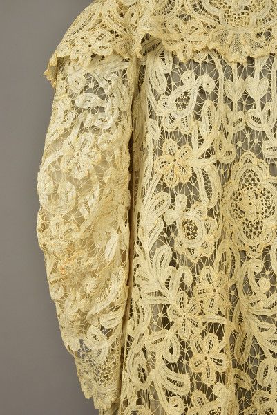 BATTENBURG LACE GOWN and COAT, 1905 - 1910. Trained ivory gown having short sleeve, square neck edged in tulle, bodice trimmed with pale gold satin and a silk and velvet corsage, flared skirt with train and a Cream lace coat having oversized collar and bell sleeve with floral worked in tapes, mixed lace fillings and trim, silk gauze lining. Tulle Bodice, Lace Coat, Battenburg Lace, 1900s Fashion, Ivory Gown, Oversized Collar, Gold Satin, Pale Gold, Cream Lace