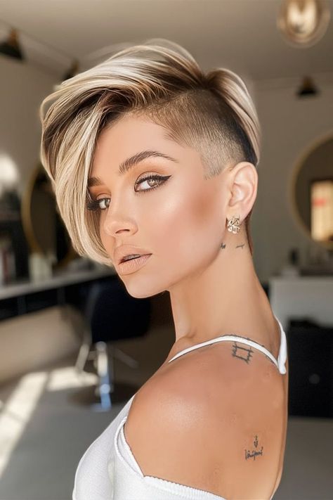 This Fall Haircut showcases a bold undercut paired with voluminous blonde highlights, creating a striking contrast. The undercut offers a sharp, edgy vibe, while the long, highlighted top adds a touch of glam. This style is perfect for those looking to combine elegance with a bit of rebellion this fall. Short Bob Undercut Hairstyles, Short Hairstyle Women Shaved Sides, Short Pixie Cut Styles, Pixie Undercut Hairstyles, Female Undercut, Long Pixie Cut With Bangs, Female Short Hairstyles, Short Undercut Hairstyles, Undercut Bob Haircut