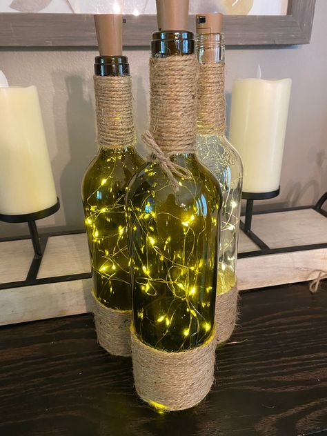 These wine bottles are filled with LED lights that look great as a center piece at your wedding or as home decor. Can be made with or without twine around the bottle. Wine Bottle Diy Wedding, Wine Themed Wedding Centerpieces, Wine Bottle Wedding Decor, Twine Wine Bottles, Bottle Art Projects, Reuse Wine Bottles, Wine Bottle Wind Chimes, Wine Bottle Centerpieces, Wedding Wine Bottles