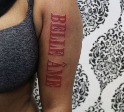 Red Bold Tattoos, Indya Marie Tattoos, Red Arm Tattoos For Black Women, Back Of Arm Tattoo Black Women, Bold Red Word Tattoo, Red Arm Tattoos For Women Forearm, Red Ink Letter Tattoo, Big Word Tattoos On Arm, Big Red Tattoo