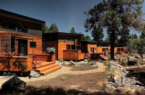 A modern tiny house community with homes and paths connecting them to the landscaping. Tiny Home Community Layout, Small House Communities, Tiny House Rentals, House Community, Lake Property, Tiny House Village, House Village, Home Design Magazines, Community Housing