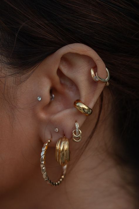 Like the rings that revolve around Saturn, these unique hoops feel like a triple threat - featuring three small hoop accents (that even move!), CZ crystals, and a perfectly sized solid gold hoop for your stack. We've never seen a hoop with as many unique elements as this, and we swear there's nothing like it. 14k Solid Gold Set with cubic zirconia crystals Dimension: 10 mm, 1.45 g Handcrafted in Italy Sold INDIVIDUALLY, not as a pair Conch Piercing Hoop Chunky, Piercing Gold Ear, Ear Ring Stack, Earring Stacks Simple, Ear Piercings Cuff, Mixed Metal Ear Stack, Mixed Metals Earring Stack, Pierced Ears Ideas, Ear Stacks Gold