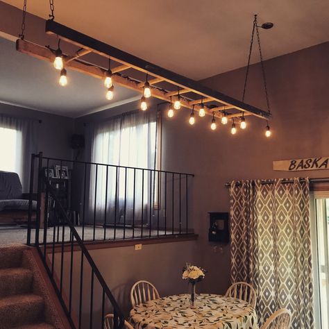 Lights Wrapped Around Beam, Ladder Hanging From Ceiling With Lights, Ladder Lights Hanging Kitchen, Ladder Lights Hanging, Hanging Ladder From Ceiling, Ladder Ceiling, Ladder Light Fixture, Ladder With Lights, Old Ladder Decor