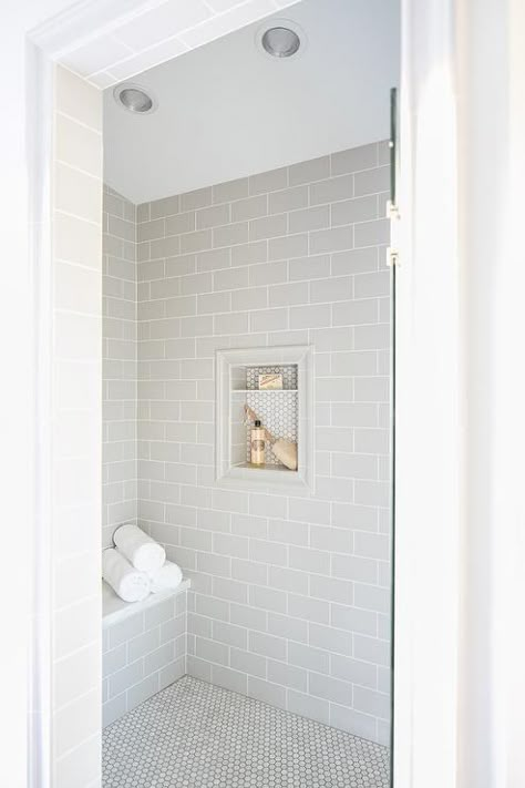 A glass door opens to a walk-in shower clad in light gray subway wall tiles fixed surrounding a tile framed niche covered in mini white hex tiles. Subway Tile Showers, Subway Tiles Bathroom, Bad Inspiration, Shower Niche, Bathroom Shower Tile, Bathroom Remodel Shower, Home Luxury, Subway Tiles, Upstairs Bathrooms