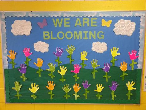 Spring bulletin board with puffy paint handprints and clouds Spring Bulletin Boards Preschool, Daycare Bulletin Boards, Toddler Bulletin Boards, Flower Bulletin Boards, Easter Bulletin Boards, Birthday Board Classroom, Preschool Boards, Summer Bulletin Boards, Spring Bulletin