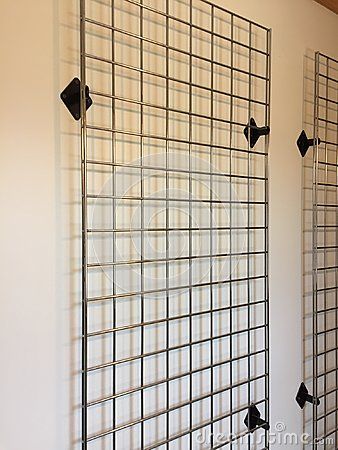 Silver metal grid with black metal holders used for hanging display items on. Never put holes in the walls again. Great to hang pictures on. Grid Wall Clothing Display, Grid Wall Retail Display, Grid Wall Design, Gridwall Display Ideas, Metal Grid Wall Decor, Wall Grid Ideas, Wire Grid Wall Display, Grid Wall Display, Wire Grid Wall