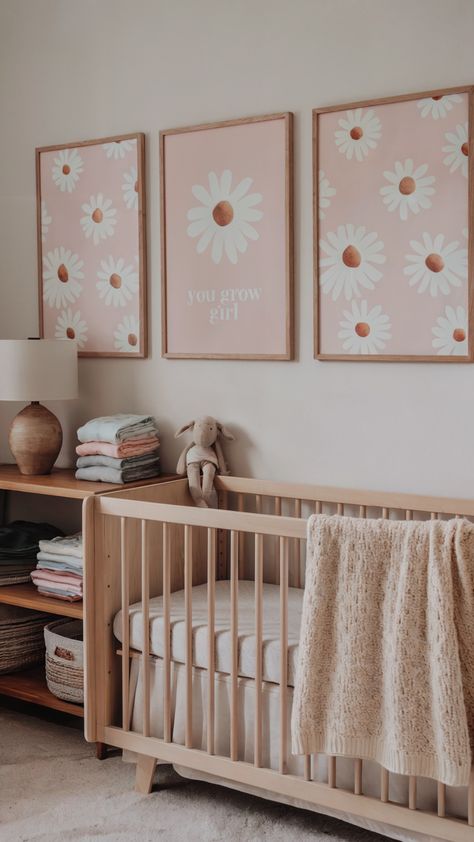 A daisy-themed baby girl nursery with soft pink wall art featuring daisies and the phrase "You grow girl," a natural wood crib, a cozy knit blanket, and a wooden shelf with folded baby linens and a plush toy lamb. The design exudes a minimalist and cheerful aesthetic. Crib Not Centered On Wall, Modern Girl Nursery Ideas, Baby Girl Nursery Flowers, Baby Girl Nursery Small Space, Baby Girl Rooms Nursery, Small Baby Girl Nursery, Infant And Toddler Shared Room, Cute Nursery Ideas Girl, Simple Girl Nursery Ideas