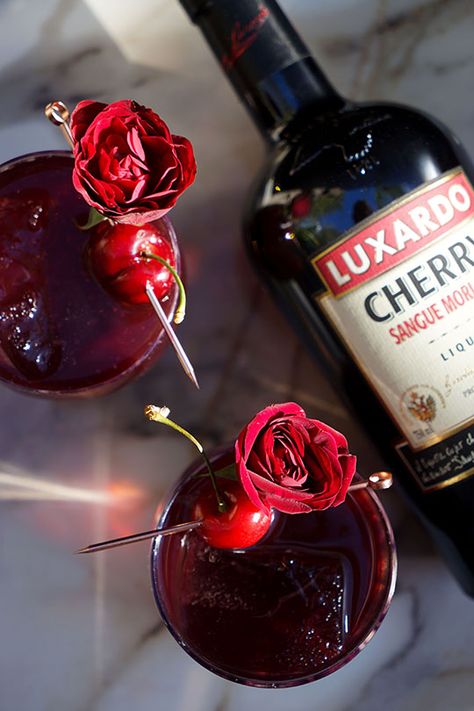 A summery cherry punch made with H by Hine Cognac, Luxardo Sangue Morlacco cherry liqueur, port, fresh lemon juice, and topped with a bottle of sparkling cherry juice and fresh flowers. Cherry Punch, Cocktails Aesthetic, Burgundy Aesthetic, Hungarian Desserts, Cherry Drink, Cherry Liqueur, Plum Jam, Cherry Wine, Cherry Juice