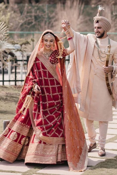 Sikh bride in a deep red Sabyasachi lehenga with the groom in an Ivory outfit भारतीय दुल्हन संबंधी, Best Indian Wedding Dresses, Pengantin India, Indian Wedding Lehenga, Groom Dress Men, Indian Groom Wear, Wedding Dresses Men Indian, Latest Bridal Lehenga, Couple Wedding Dress