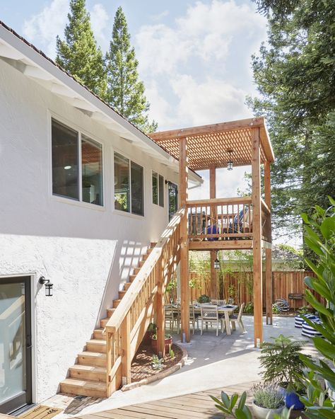 Outdoor, Vertical Fences, Wall, Back Yard, Hanging Lighting, Wood Patio, Porch, Deck, Wood Fences, Wall, Large Patio, Porch, Deck, Shrubs, and Trees A view of the new redwood structure, complete with rebuilt stairs. "It has basically made the house look 100% better from the outside," Soria said. Balcony Stairs Outdoor, Two Story Deck Ideas, 2nd Floor Deck Ideas, Patio With Stairs, Small Back Deck, 70s Home Exterior, Modern 70s Home, Deck Skirt, Apartment Stairs