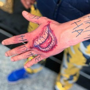 Jokers Smile Tattoo On Hand, Joker Mouth Hand Tattoo, Joker Smile Tattoo Design, Joker Hand Tattoo Design, Tattoo Designs Joker, Joker Mouth Drawing, The Joker Hand Tattoo, Joker Smile Hand Tattoo For Women, Jokers Hand Tattoo