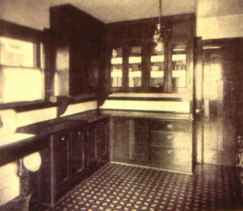 An early installation of kitchen cupboards c1905. Wood counter tops and sink drains were common to begin with. Note the lack of ‘toe-kick’ space. The floor is patterned linoleum. Here it is a ‘mosaic’ lino, which was popular through the 1890’s into the 1910’s. Small pieces of different coloured lino were glued into patterns at the factory and available in rolls. Printed linoleums became popular – known as “Art squares” - from 1905 through the 1920’s and later. 1910 Kitchen, 1900s Kitchen, 1920s Kitchen, Historic Kitchen, Craftsman Kitchen, Victorian Kitchen, Heritage House, Countertop Design, Antique Kitchen