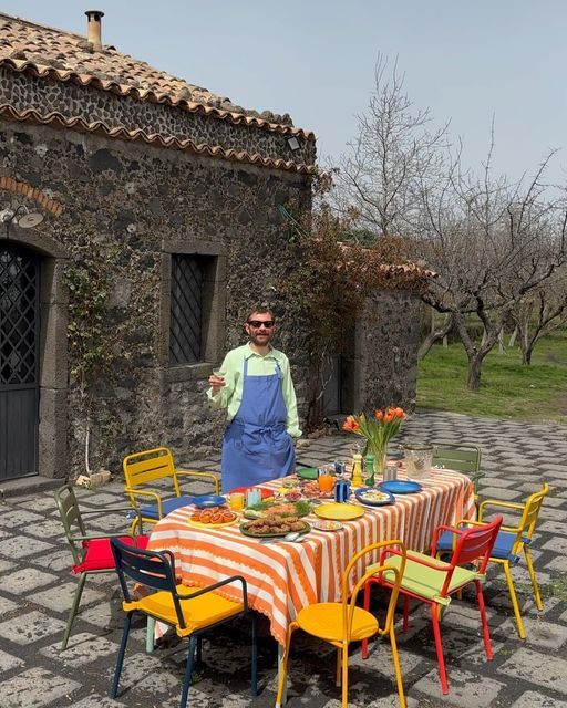 a man standing next to a table covered in food