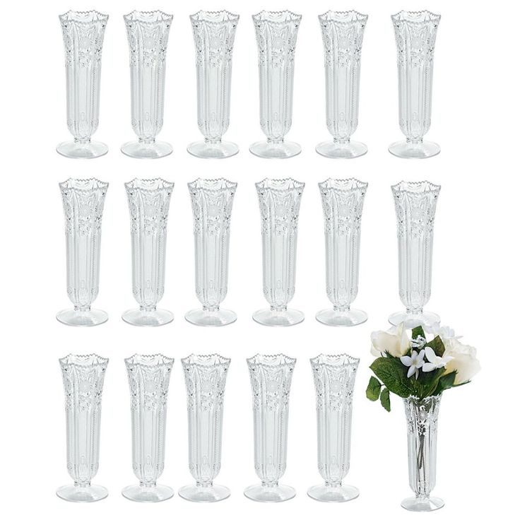 twelve clear glass vases with white flowers in the middle and one on each side