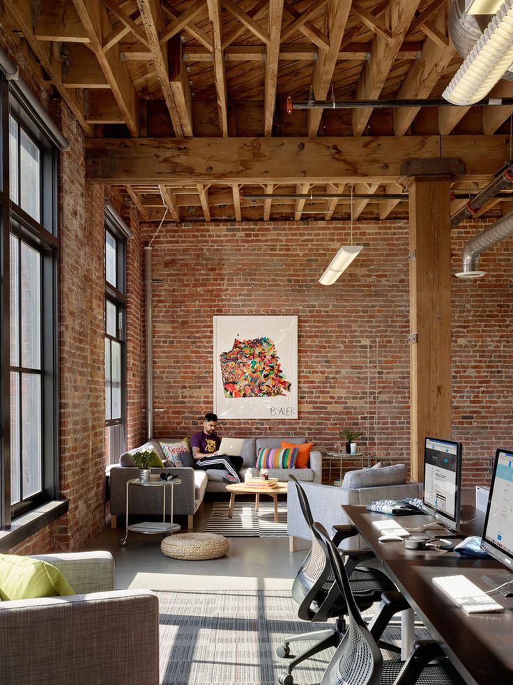 an office with brick walls and exposed ceilings