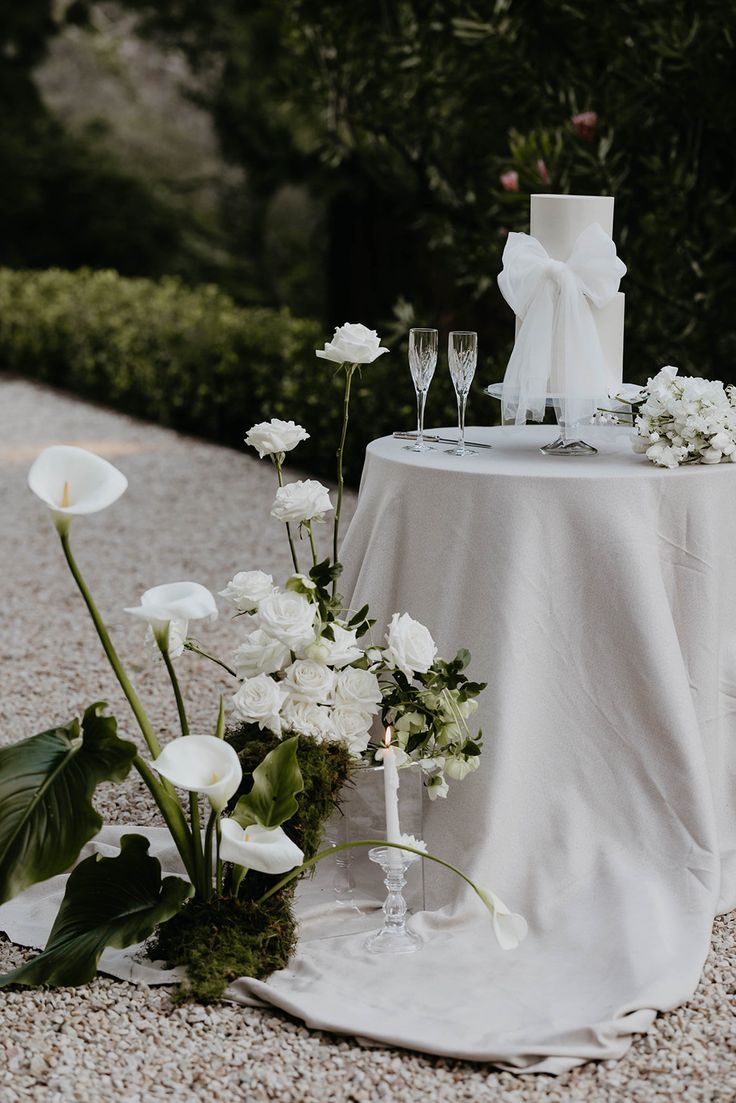 the table is set with white flowers and wine glasses