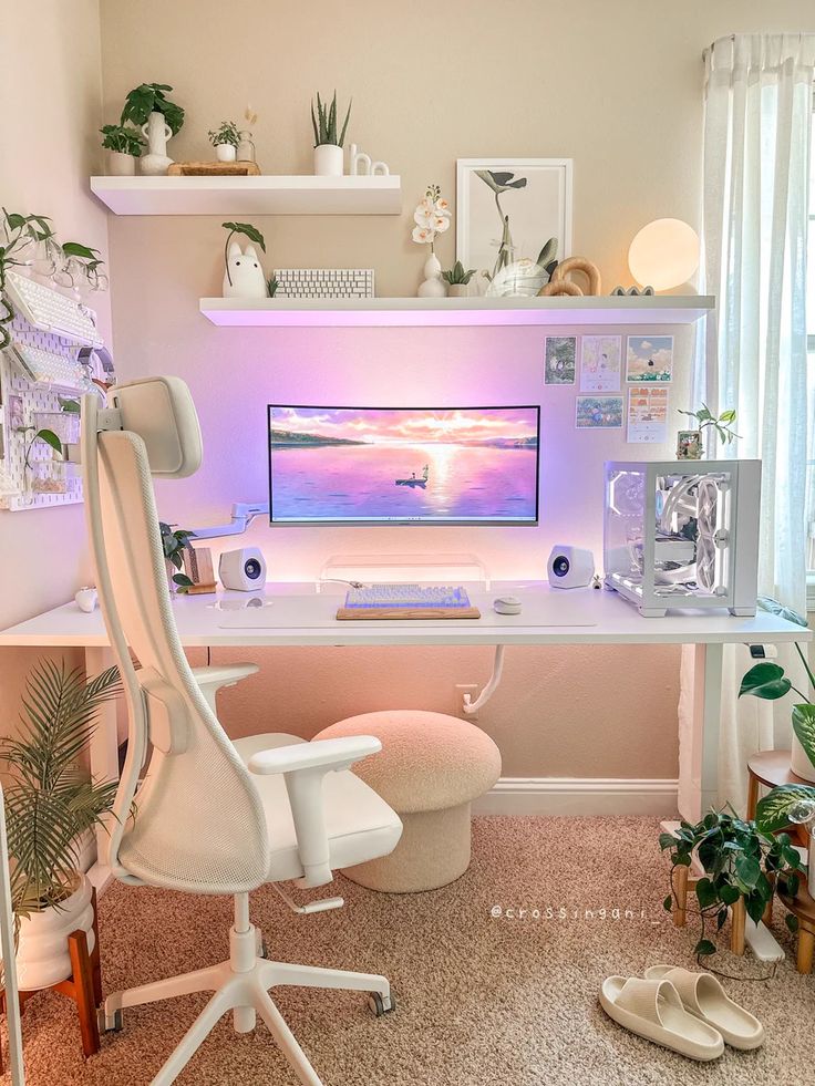 a desk with a computer on it and some plants in the corner next to it