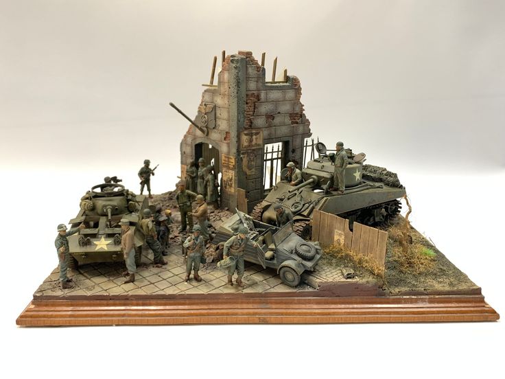 a group of toy soldiers standing in front of a building with tanks on top of it