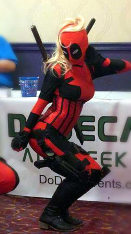 a woman in a deadpool cosplay is holding a bat and posing for the camera