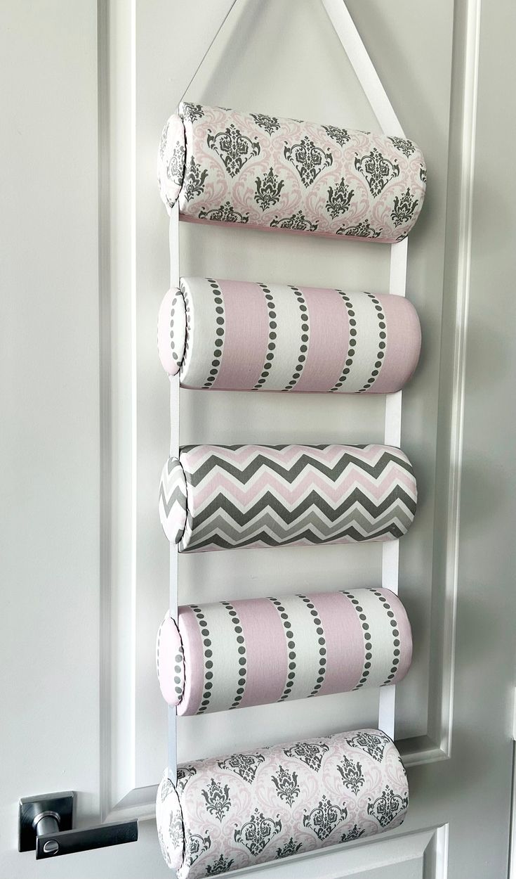 four rolls of fabric hanging on a wall