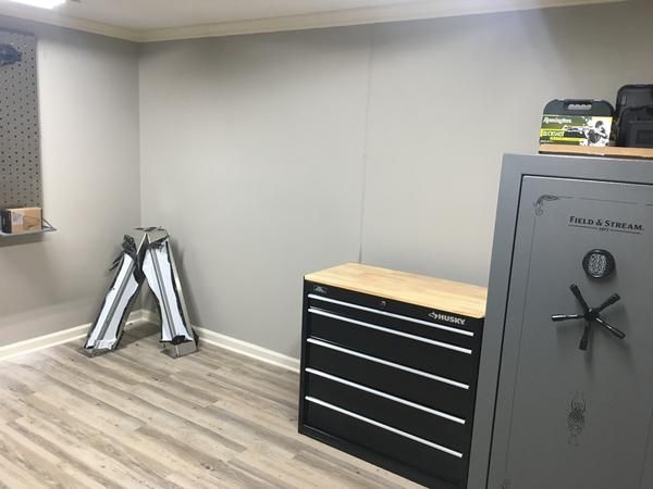 an empty room with tools on the floor and a tool cabinet in front of it