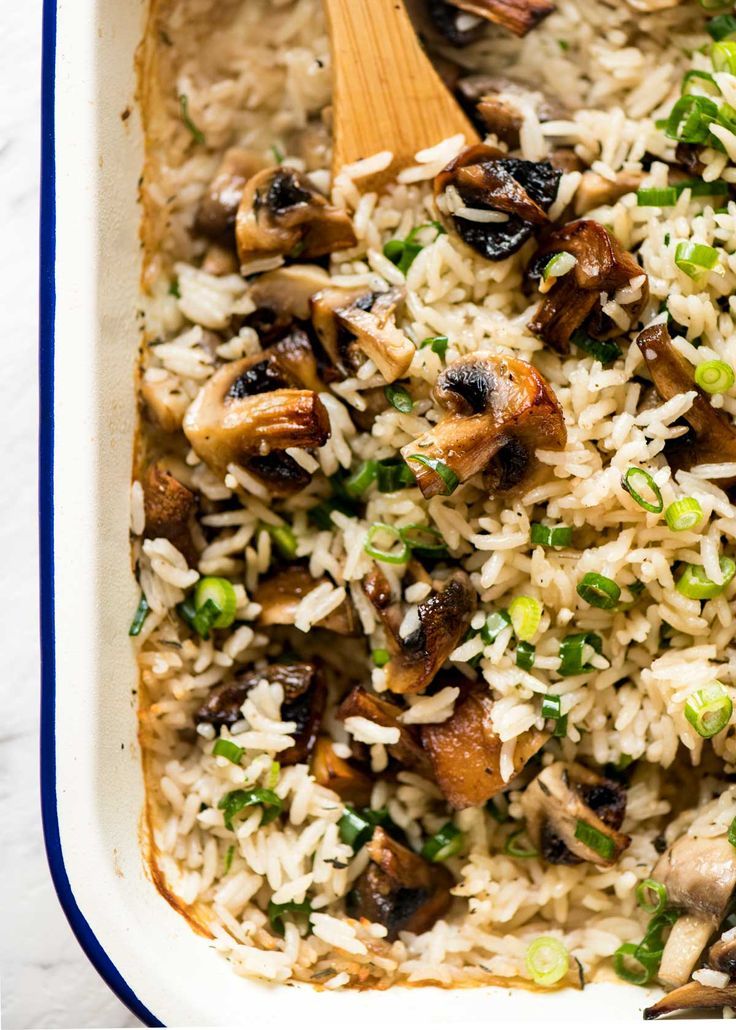 rice with mushrooms and green onions in a white casserole dish