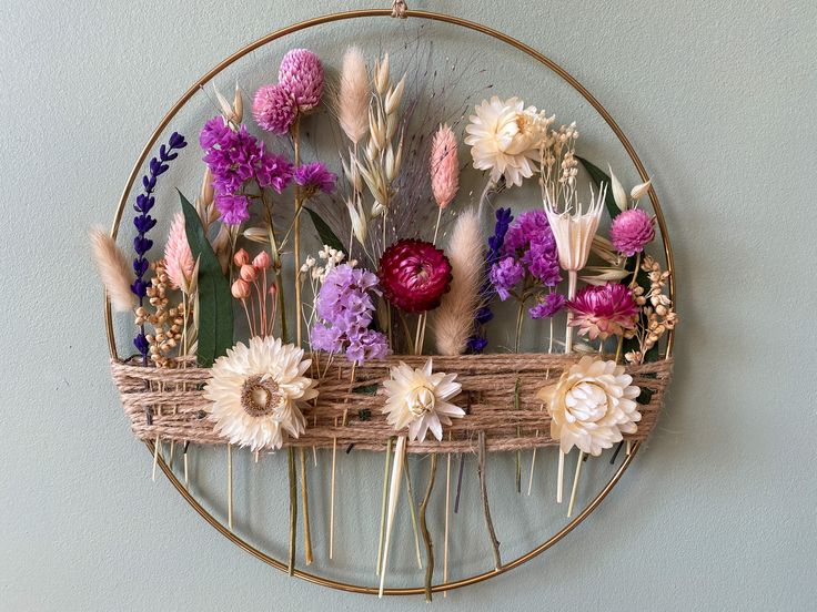 a metal circle with flowers in it hanging on the wall