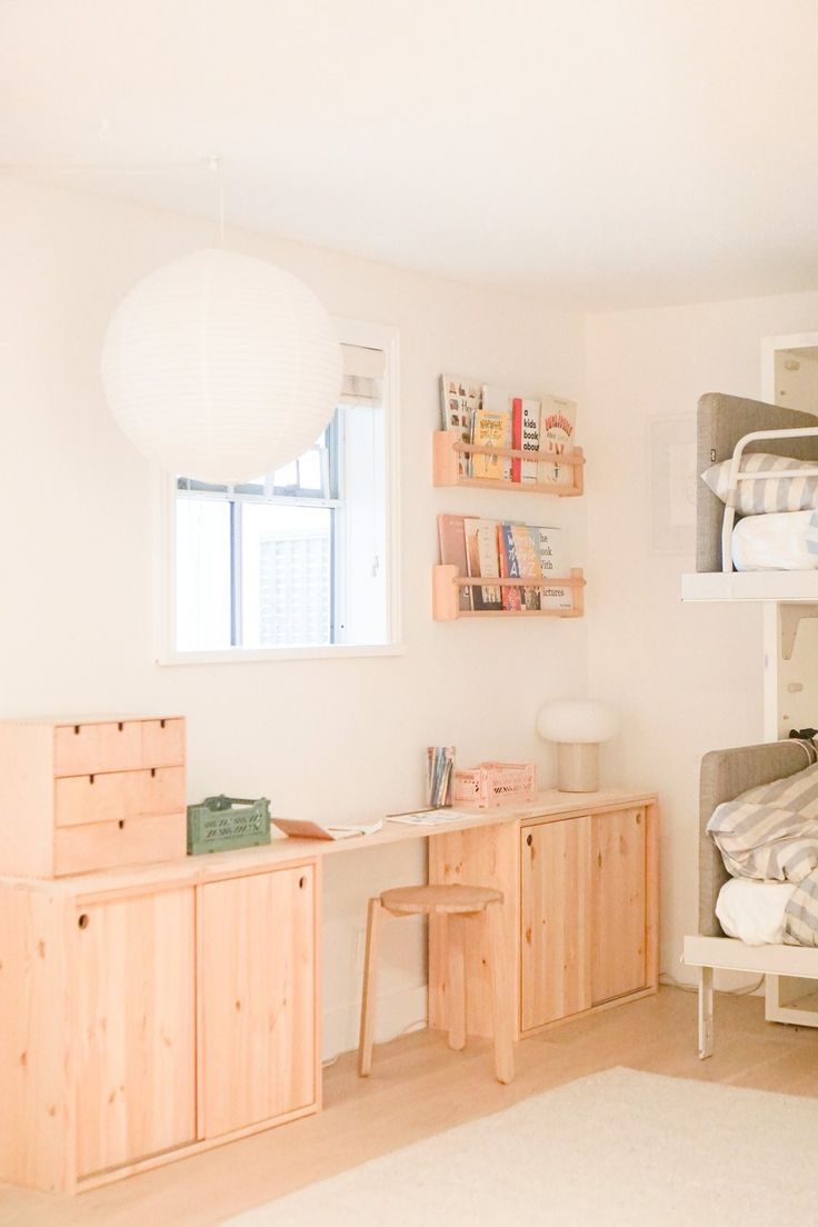 a bedroom with bunk beds and desks in it