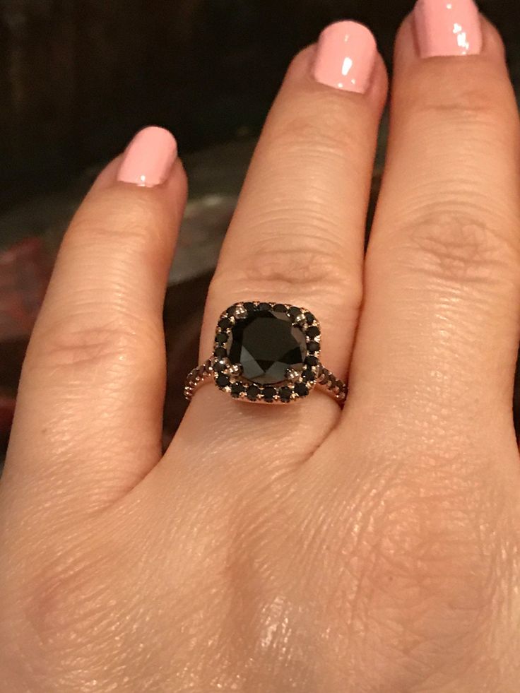 a woman's hand with a black diamond ring on it