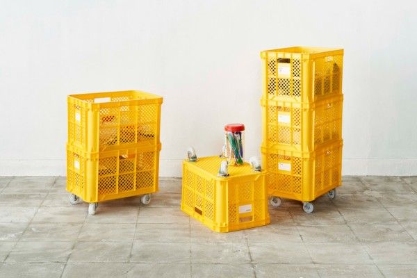 two yellow crates sitting next to each other on top of a tile floor in front of a white wall