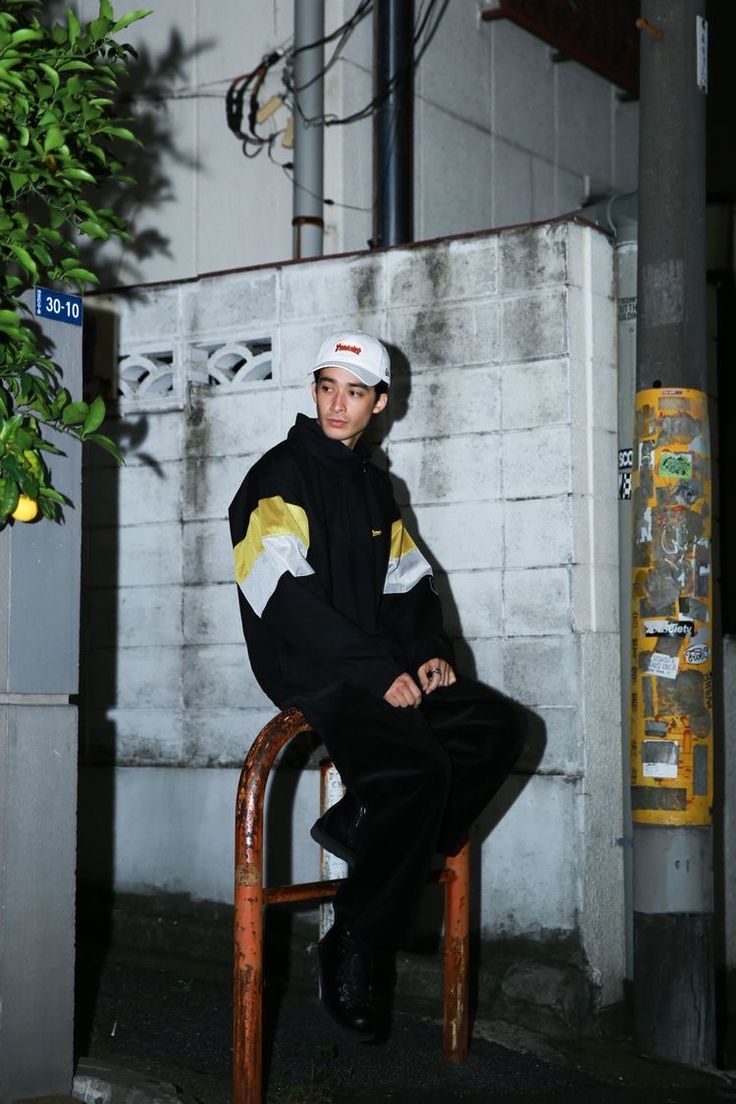 a young man sitting on top of a wooden chair