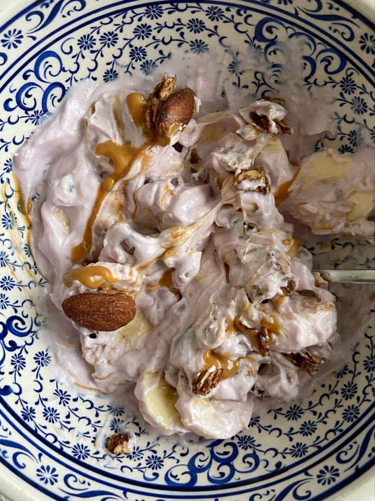 a blue and white bowl filled with food on top of a table