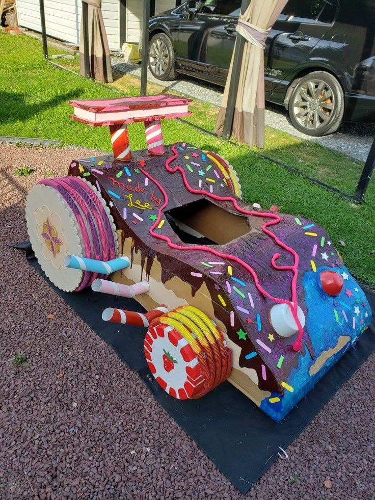 a car made out of cardboard sitting on the ground