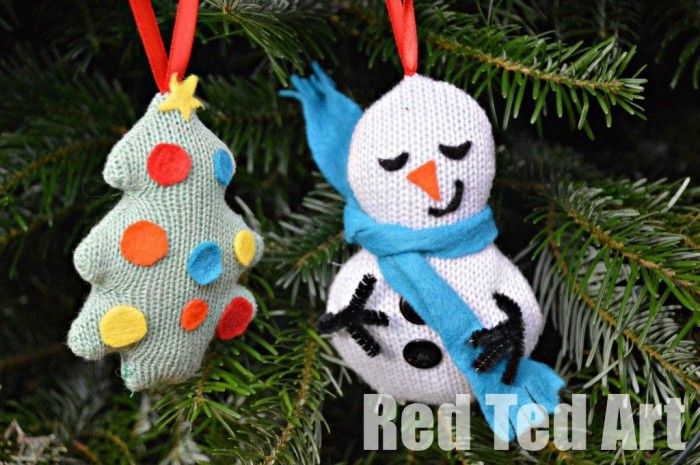 two snowman ornaments hanging from a christmas tree