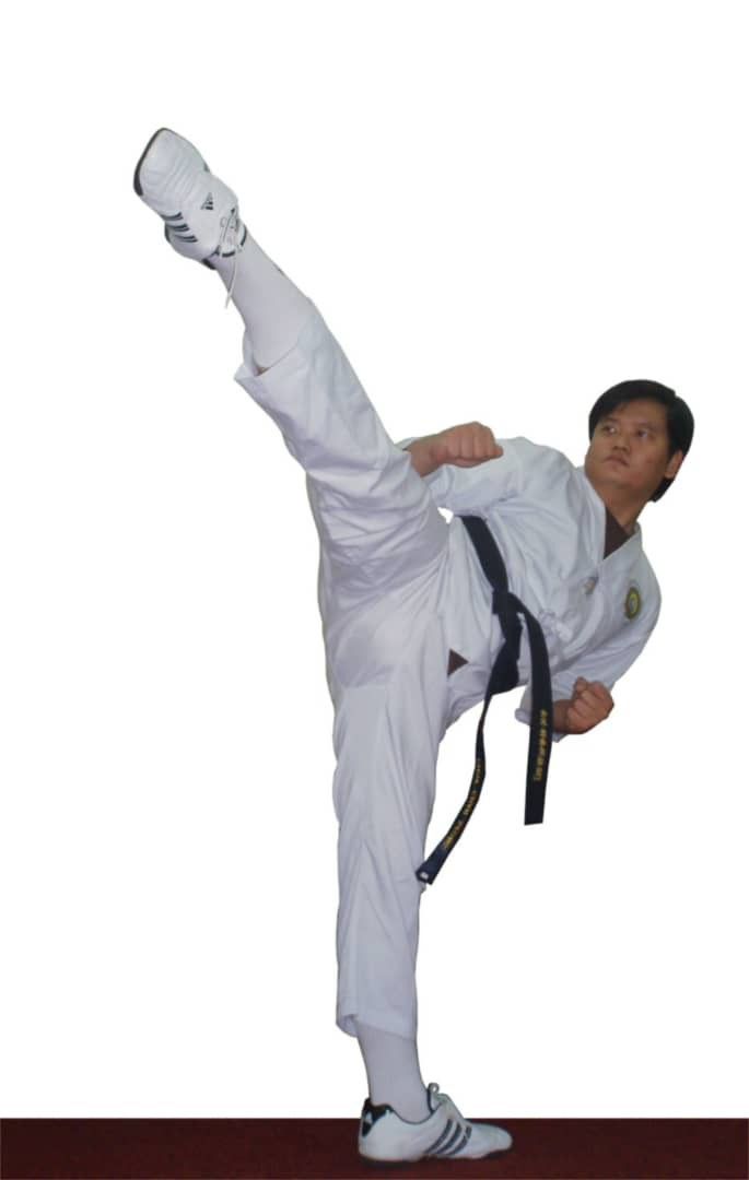 the man is practicing his karate moves in front of a white background and black belt