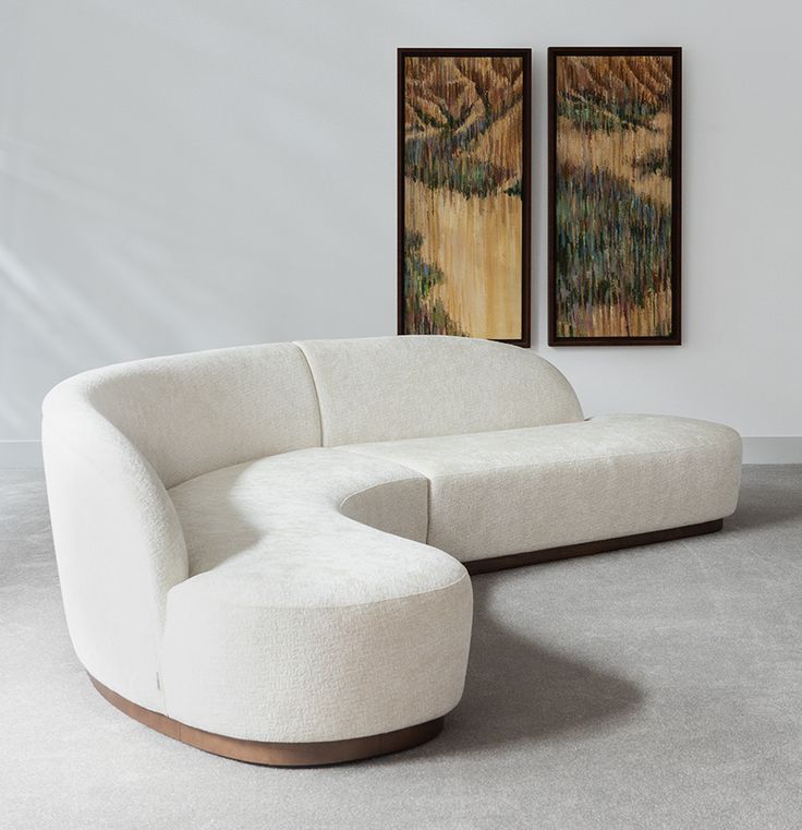 a large white couch sitting next to a painting on the wall in a living room