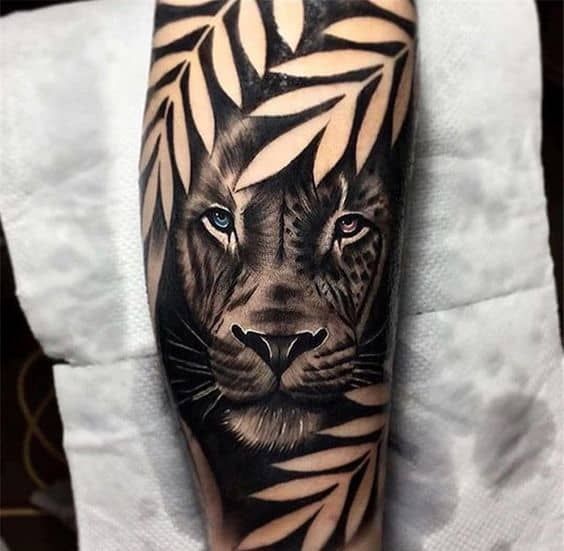 a black and white tiger with blue eyes on his arm, done by an artist