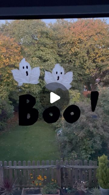 a window with the words boo on it and ghost faces drawn in front of them