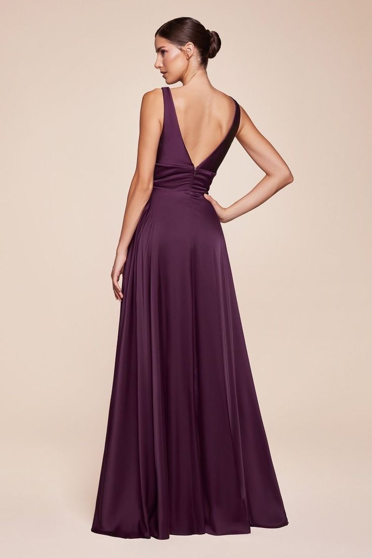 a woman in a long purple dress is looking back at the camera with her hands on her hips