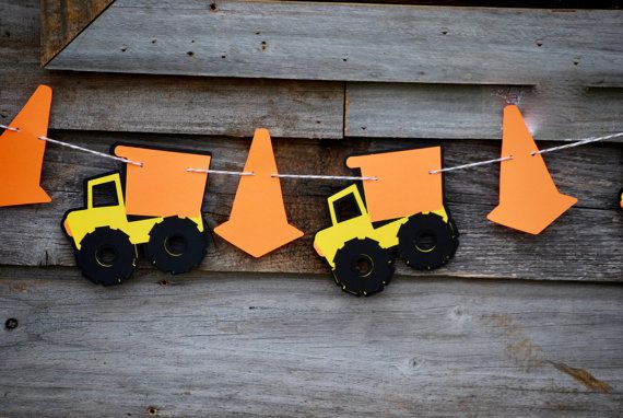 this is a construction themed banner made out of construction paper and construction vehicles hanging on a line