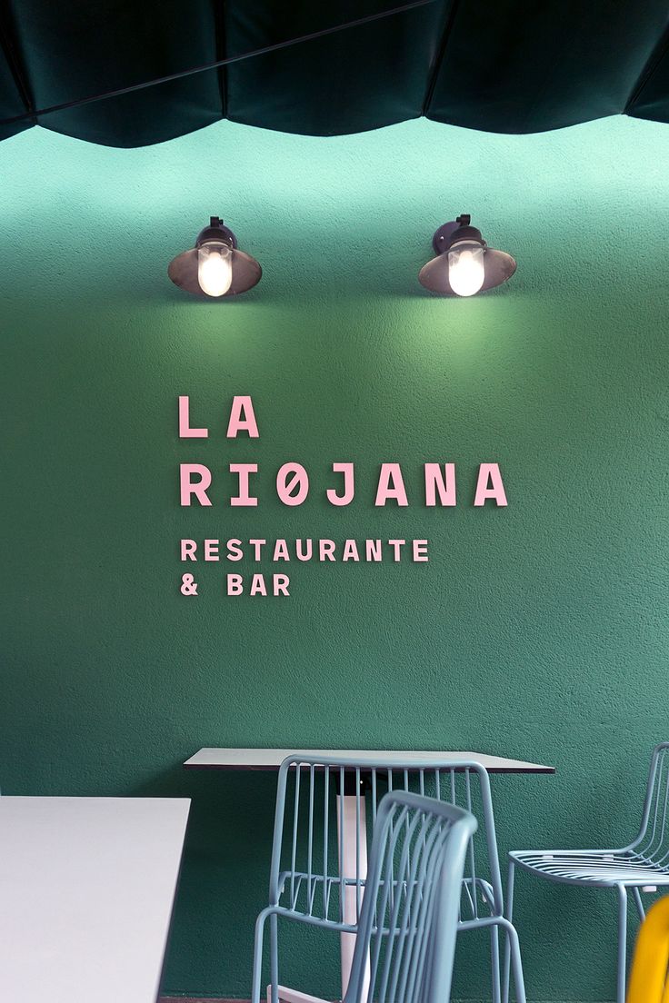 the interior of a restaurant with green walls and white tables, yellow chairs and black awnings