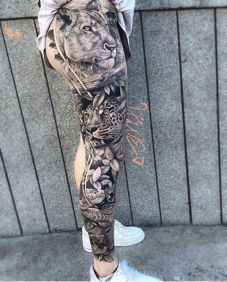 a man's leg with tattoos on it that has a lion and flowers on it