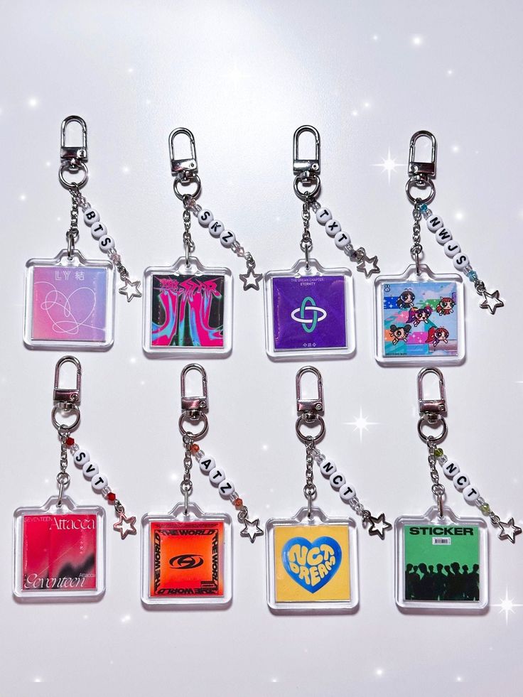 six square key chains with pictures on them hanging from each one's side, all in different colors