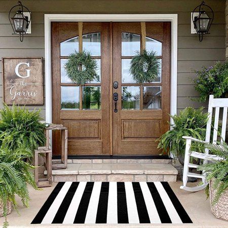 front porch with two rocking chairs and potted plants on the steps to the front door