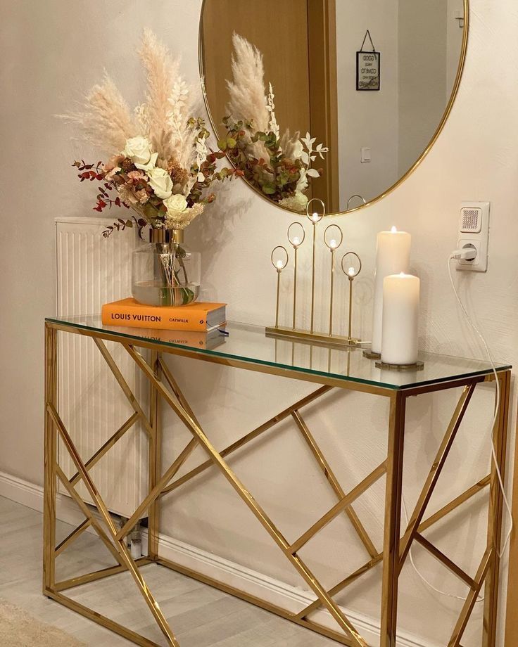 a console table with flowers and candles on it