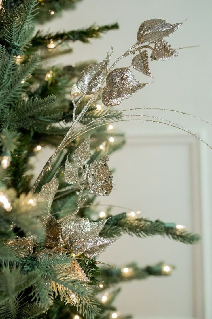 a christmas tree is decorated with silver and gold ornaments