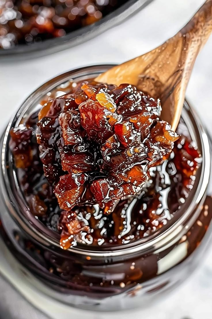 a wooden spoon in a jar filled with jelly