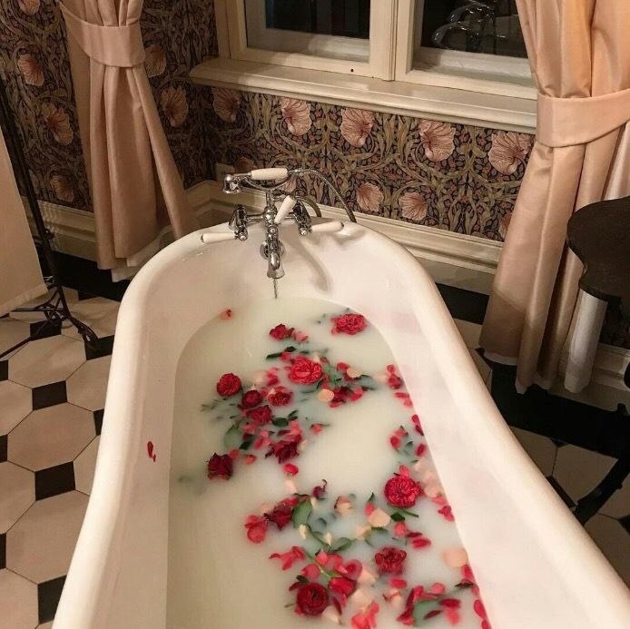 a bathtub filled with water and red flowers