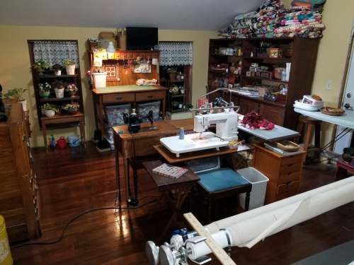 a sewing studio with lots of crafting supplies on the desks and shelves in it